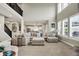 Inviting living room featuring a view of the staircase, large windows, and seamless transition to the kitchen at 15023 Glenmoor Cir, Carmel, IN 46033