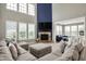 Bright, open living room featuring a stone fireplace, large windows, and comfortable sectional sofa at 15023 Glenmoor Cir, Carmel, IN 46033