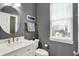 Stylish powder room features gray walls, a round mirror, and a modern vanity at 15023 Glenmoor Cir, Carmel, IN 46033
