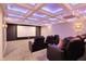 Home theater room featuring reclining chairs, projector, and coffered ceiling with blue lighting at 15023 Glenmoor Cir, Carmel, IN 46033