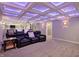 Home theater with comfortable seating, projector, and stylish coffered ceiling with blue lighting at 15023 Glenmoor Cir, Carmel, IN 46033