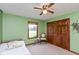 Bedroom with bright green walls, a ceiling fan, a window, and a wooden closet door at 1607 Michelle Manor, Danville, IN 46122