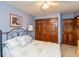 Bedroom showcasing a bed with blue and white floral accents, a ceiling fan, and wooden closet doors at 1607 Michelle Manor, Danville, IN 46122
