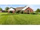 Beautiful brick home with lush green lawn and manicured landscaping offers a welcoming curb appeal at 1607 Michelle Manor, Danville, IN 46122