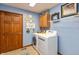 Functional laundry room with blue walls, washer, dryer, and built in storage at 1607 Michelle Manor, Danville, IN 46122