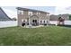 View of the home's backyard with a concrete patio, lawn, and play set at 1661 Devonshire Ave, Avon, IN 46123
