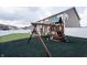 View of the backyard's wooden play set with swings, slide, and climbing area at 1661 Devonshire Ave, Avon, IN 46123