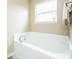 An inviting soaking tub with chrome fixtures and a bright window at 1661 Devonshire Ave, Avon, IN 46123