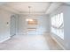 Neutral dining room featuring a chandelier, light gray walls, trim, carpet, and a window for natural light at 1661 Devonshire Ave, Avon, IN 46123
