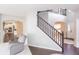 View of the entry way with staircase and chair, showcasing open layout and hardwood floors at 1661 Devonshire Ave, Avon, IN 46123