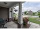 Inviting front porch with hanging plants, exterior lamp, white columns, and vibrant flowering bushes on property at 1661 Devonshire Ave, Avon, IN 46123