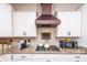 Modern kitchen with granite countertops, stainless steel appliances, and a decorative range hood at 1661 Devonshire Ave, Avon, IN 46123