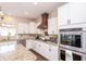 Updated kitchen with stainless appliances, granite counters, and a decorative range hood at 1661 Devonshire Ave, Avon, IN 46123