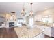 Open kitchen with granite countertops, chandeliers and seamless flow into dining and living areas at 1661 Devonshire Ave, Avon, IN 46123