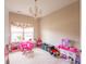 Bright playroom with a chandelier, neutral walls, window with decorative curtains, and toys at 1661 Devonshire Ave, Avon, IN 46123