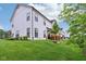 Back of home with white siding, dark framed windows, grassy backyard, and wooden decks at 17551 Gruner Way, Westfield, IN 46062