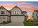 Charming two-story home features a white facade, attached garage, and well-manicured lawn at sunset at 17551 Gruner Way, Westfield, IN 46062