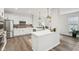 Bright, open kitchen with white cabinets, stainless steel appliances, hardwood floors, and modern lighting at 17551 Gruner Way, Westfield, IN 46062