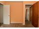 Bedroom with orange painted walls, beige carpet, and two doors at 1802 Sugar Grove Ave, Indianapolis, IN 46202