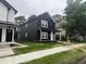 Beautiful modern home with dark siding, white trim, and a covered porch in a neighborhood setting at 1802 Sugar Grove Ave, Indianapolis, IN 46202