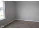 A minimalist bedroom features light gray walls, neutral carpet and a window view at 1813 Real St, Indianapolis, IN 46240