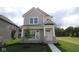 Charming two-story home features board and batten siding, a covered porch, and a well-manicured lawn at 1813 Real St, Indianapolis, IN 46240