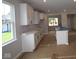 Kitchen with white cabinets, a kitchen island with sink, and views to the back yard at 1813 Real St, Indianapolis, IN 46240