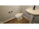 Powder room features a pedestal sink, toilet and wood flooring at 1813 Real St, Indianapolis, IN 46240