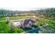 Aerial view showcases a community clubhouse, pool, playground, and pond, surrounded by lush landscaping and trees at 1821 Midnight Pass, Brownsburg, IN 46112