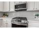 Modern kitchen features stainless steel appliances, white cabinetry, and stylish gray subway tile backsplash at 1821 Midnight Pass, Brownsburg, IN 46112