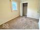 Carpeted bedroom featuring a window for natural light and closet for storage at 1834 Chandler Ln, Columbus, IN 47203