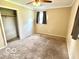 Carpeted bedroom featuring a ceiling fan, window, and closet for storage at 1834 Chandler Ln, Columbus, IN 47203