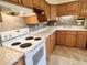 Traditional kitchen featuring wood cabinetry, laminate countertops, and a white electric range at 1834 Chandler Ln, Columbus, IN 47203