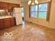 Kitchen area featuring a window overlooking the back yard and a full sized refrigerator at 1834 Chandler Ln, Columbus, IN 47203