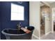 This bathroom has a modern, black, free-standing tub with a gold faucet and a shower with a glass door at 18398 Cross Lakes Ct, Westfield, IN 46074