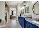 A bathroom with double sinks, blue cabinets, granite countertops, and a separate tiled glass shower at 18398 Cross Lakes Ct, Westfield, IN 46074