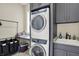 Well-organized laundry room with stacked washer and dryer, counter space, and ample cabinetry at 18398 Cross Lakes Ct, Westfield, IN 46074