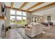 Sunlit living room featuring exposed wood beams, fireplace, and large windows overlooking a pond at 18398 Cross Lakes Ct, Westfield, IN 46074
