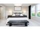 This main bedroom features neutral tones, natural lighting and a dark bench to highlight this relaxing space at 18736 Moray St, Westfield, IN 46074