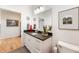 Well-lit bathroom showcasing white cabinetry, granite counters, stylish decor, and wood-look flooring at 201 St Andrews Ave, Edinburgh, IN 46124