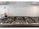 Modern kitchen features a stainless steel gas range with black countertop and white subway tile backsplash at 201 St Andrews Ave, Edinburgh, IN 46124