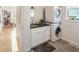 Bright laundry room with stacked washer and dryer, undermount sink, and views to the outside at 201 St Andrews Ave, Edinburgh, IN 46124