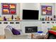 Close-up of living room fireplace with white subway tile and built-in cabinets displaying colorful glassware at 201 St Andrews Ave, Edinburgh, IN 46124