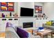 Living room fireplace featuring a black frame, white subway tile surround and custom-built white cabinets with colorful decor at 201 St Andrews Ave, Edinburgh, IN 46124
