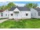 Charming home with a well-maintained front lawn, a white exterior, and classic architectural details at 2015 S Hackley St, Muncie, IN 47302