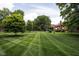 Well-manicured lawn with professionally striped lawn, mature trees, and brick home visible in the background at 2263 Rome Dr, Indianapolis, IN 46228