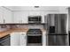 Bright kitchen featuring stainless steel appliances, brick backsplash, and white cabinetry at 2263 Rome Dr, Indianapolis, IN 46228