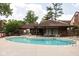 Community pool with ample seating and lounge chairs in a brick-lined building shaded by mature trees at 2263 Rome Dr, Indianapolis, IN 46228