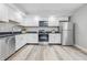 Contemporary kitchen with white cabinets, stainless steel appliances, and light wood flooring at 2315 Spann Ave, Indianapolis, IN 46203
