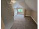 Cozy attic space featuring neutral carpeting, natural light from a window and interesting architectural detailing at 24 N Randolph St, Indianapolis, IN 46201